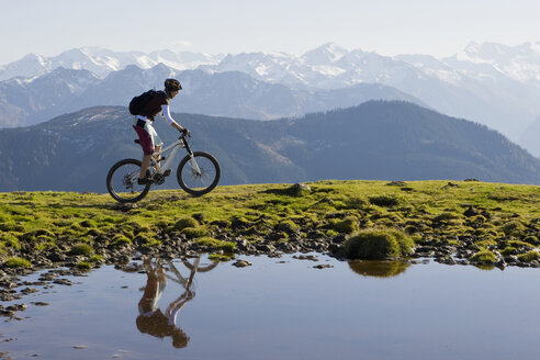 Austria, Salzburger Land, Zell am See, Woman mountain biking - FFF01025
