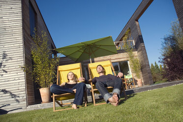 Germany, Bavaria, Munich, couple sunbathing on loungers - NHF01071