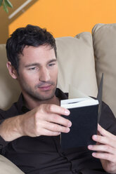 Young man reading a book, portrait - NHF01065