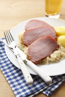 Geräuchertes Schweinekotelett, mit Kartoffeln und Sauerkraut auf dem Teller - KSWF00261