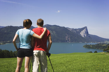 Austria, Lake Mondsee, Young couple looking at lake, rear view - WWF00364