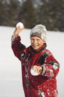 Österreich, Steiermark, Junge (12-13) hält Schneeball, lächelnd, Porträt - WWF00360