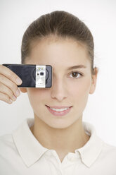 Young woman (16-17) holding mobile phone, close up - TCF01176