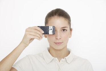 Young woman (16-17) holding mobile phone, close up - TCF01175