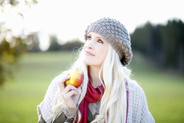 Junge Frau, die einen Apfel hält, Porträt - MAEF01461