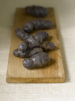 Blauviolette Kartoffeln mit Trüffel de Chine auf dem Schneidebrett - KSW00346