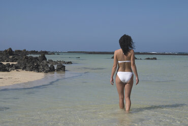 Spanien, Lanzarote, Orzola, Junge Frau im Bikini, Rückansicht - UMF00263