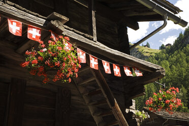 Schweiz, Walliser Alpen, Val d'Herens, Les Hauderes, Blockhaus mit Schweizer Bannern geschmückt - GWF00947