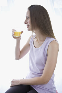 Junge Frau hält ein Glas Saft, Porträt - WESTF10938
