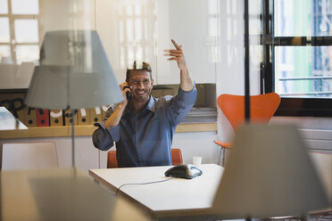 Young man in office using telephone - WESTF10731