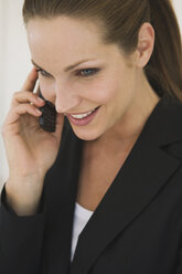 Business woman using mobile phone, portrait, close-up - WESTF10716