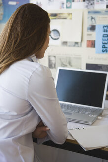 Junge Frau im Büro mit Laptop - WESTF10708