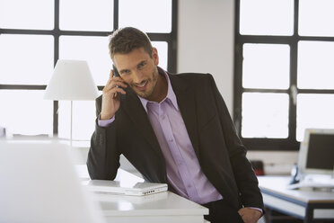 Business man using mobile phone, smiling, portrait - WESTF10647