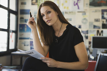 Young business woman checking contract, portrait - WESTF10620