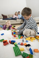 Familie entspannt sich zu Hause, Kinder spielen mit Bauklötzen - CLF00676
