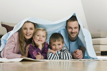 Family covered with blanket, smiling - CLF00674