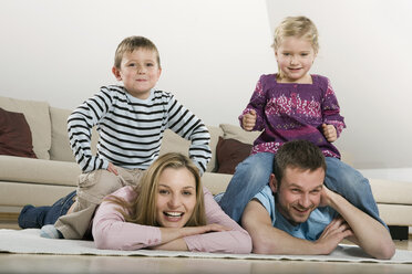 Familie entspannt zu Hause, lächelnd - CLF00671