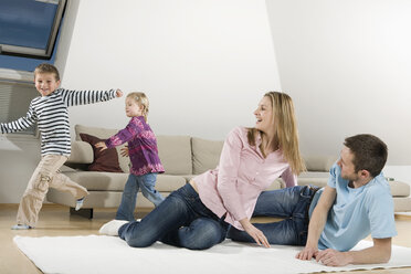 Family relaxing at home, children frolicking - CLF00670