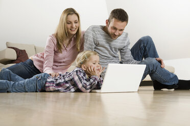Parents and daughter (3-4) at home, using laptop - CLF00658
