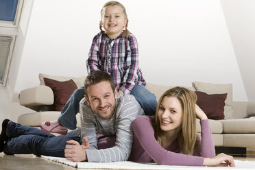 Parents and daughter (3-4), relaxing at home - CLF00645