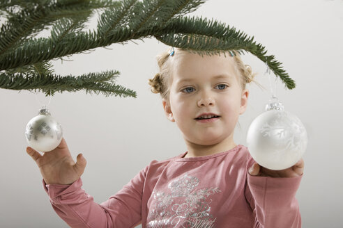 Kleines Mädchen (3-4) betrachtet eine Weihnachtskugel - CLF00632