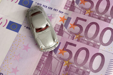 Toy car placed on Euro notes, elevated view - RUEF00143