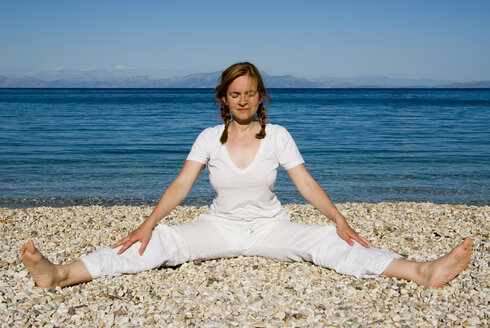 Greece, Ithaca, Woman exercising yoga on beach - MUF00762