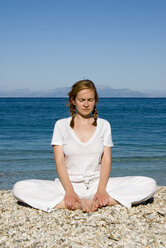 Greece, Ithaca, Woman exercising yoga on beach - MUF00761