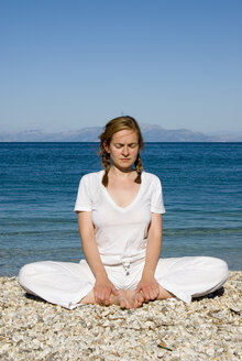 Griechenland, Ithaka, Frau übt Yoga am Strand - MUF00761