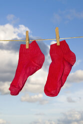 A pair of red socks hanging on clothesline - MUF00757