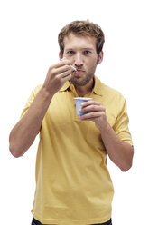Young man eating Yoghurt, portrait - BMF00535