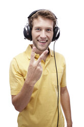 Junger Mann mit Kopfhörern, zeigt Finger, Porträt - BMF00526