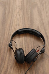 Headphones on wooden table, elevated view - KJF00017