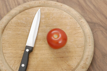Tomate und Messer auf Schneidebrett, Ansicht von oben - KJF00003