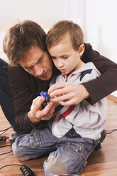 Father and son (4-5) playing with toy racetrack - WESTF10972