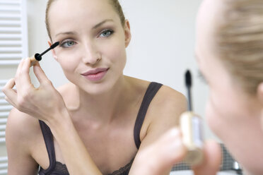 Young woman applying mascara, portrait, close-up - WESTF10813