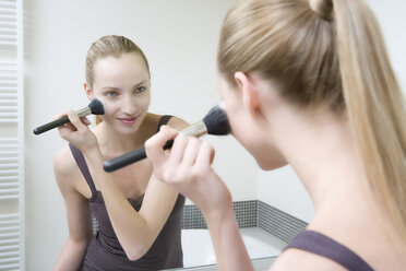 Young woman using make-up brush - WESTF10806