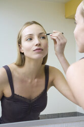 Young woman plucking her eyebrows - WESTF10796