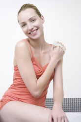 Junge Frau mit Massagehandschuh, lächelnd, Porträt - WESTF10777