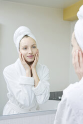 Young woman looking in mirror, portrait - WESTF10751