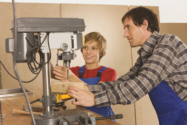 Germany, father and son , Working on drill machine - WESTF11037