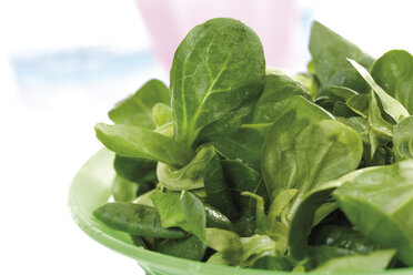Field salad in plastic bowl, close-up - 10336CS-U
