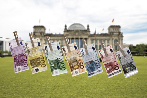 Deutschland, Berlin, Euro-Banknoten hängen an einer Wäscheleine, Reichstagsgebäude im Hintergrund - 10655CS-U