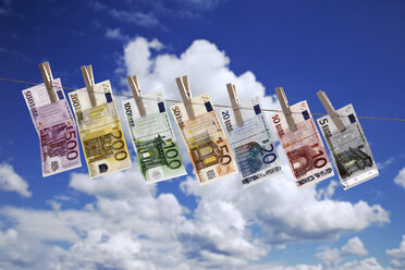 Different Euro bank notes hanging on clothesline against cloudy sky - 10654CS-U