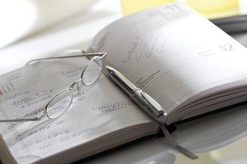 Notebook, eyeglasses and pen, close-up - 10642CS-U