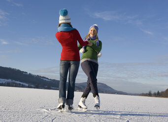 Austria, Salzkammergut, Lake Irrsee, Female teenagers (14-15) skating and dancing - WWF00834