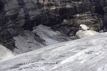 Norway, Nigardsbreen, Tourists walking across glacier tongue - MR01194