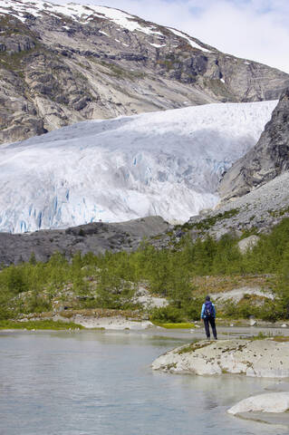 Norwegen, Nigardsbreen, Gletscherzunge, Wanderer am Ufer, Rückansicht, lizenzfreies Stockfoto