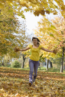 Austria, Female teenager (14-15), running across park, having fun - WWF00856