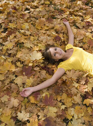 Österreich, Weiblicher Teenager (14-15), entspannt auf Blättern, Blick von oben - WWF00852